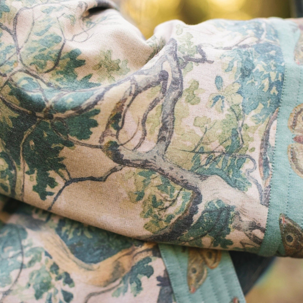 
                  
                    Model wearing Earth and Sky Cottage Jacket – featuring Charles Aston’s tree painting and antique moth art – cozy fleece-lined cardigan for cooler days – Market of Stars.
                  
                