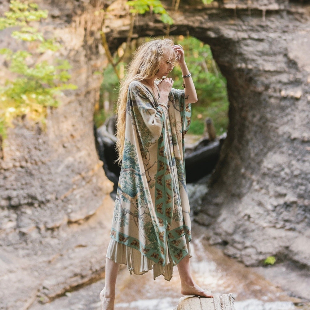 
                  
                    Model wearing the Earth and Sky Goddess length kimono featuring majestic trees by Charles Aston and antique moth illustrations – a dreamy tribute to nature – Market of Stars.
                  
                
