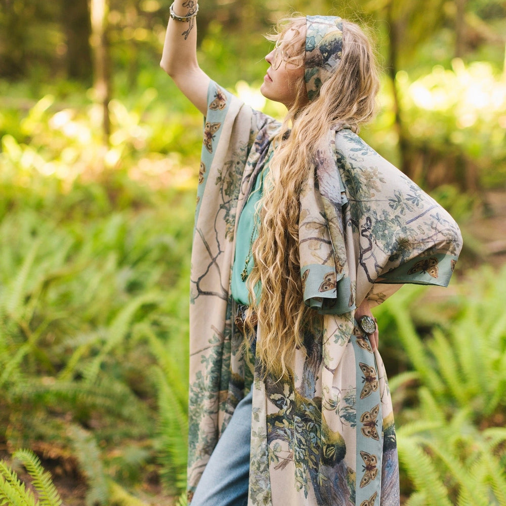 
                  
                    Model wearing the Earth and Sky Goddess length kimono featuring majestic trees by Charles Aston and antique moth illustrations – a dreamy tribute to nature – Market of Stars.
                  
                
