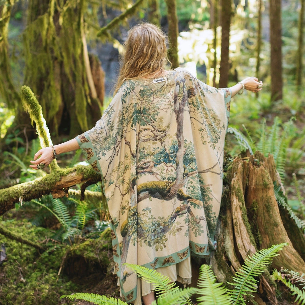 
                  
                    Model wearing the Earth and Sky Goddess length kimono featuring majestic trees by Charles Aston and antique moth illustrations – a dreamy tribute to nature – Market of Stars.
                  
                