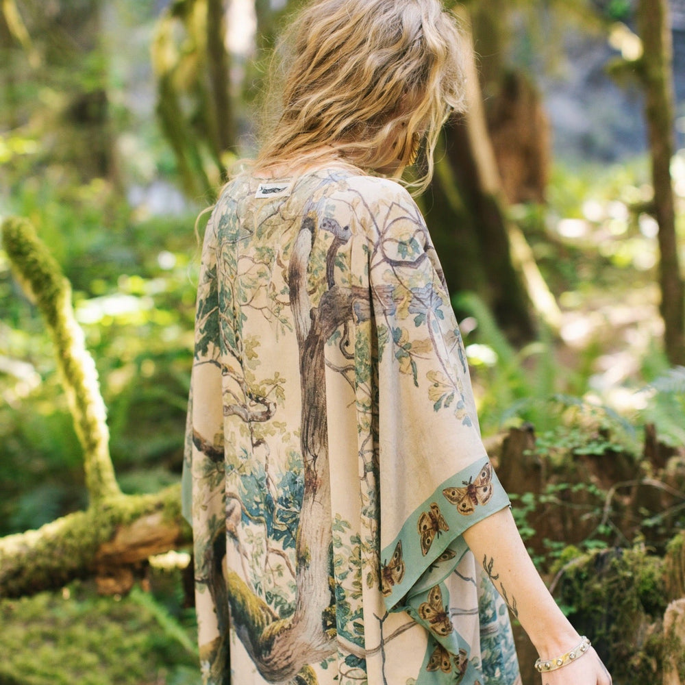 
                  
                    Model wearing the Earth and Sky Goddess length kimono featuring majestic trees by Charles Aston and antique moth illustrations – a dreamy tribute to nature – Market of Stars.
                  
                