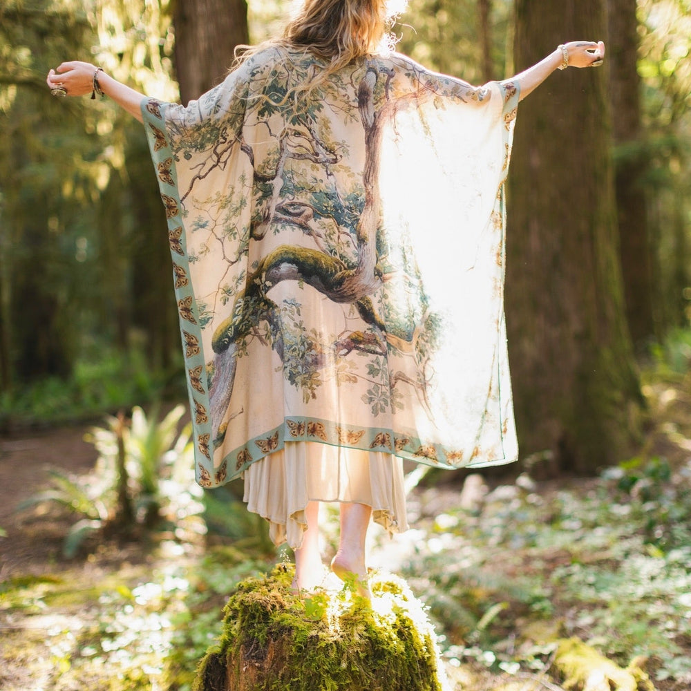 
                  
                    Model wearing the Earth and Sky Goddess length kimono featuring majestic trees by Charles Aston and antique moth illustrations – a dreamy tribute to nature – Market of Stars.
                  
                