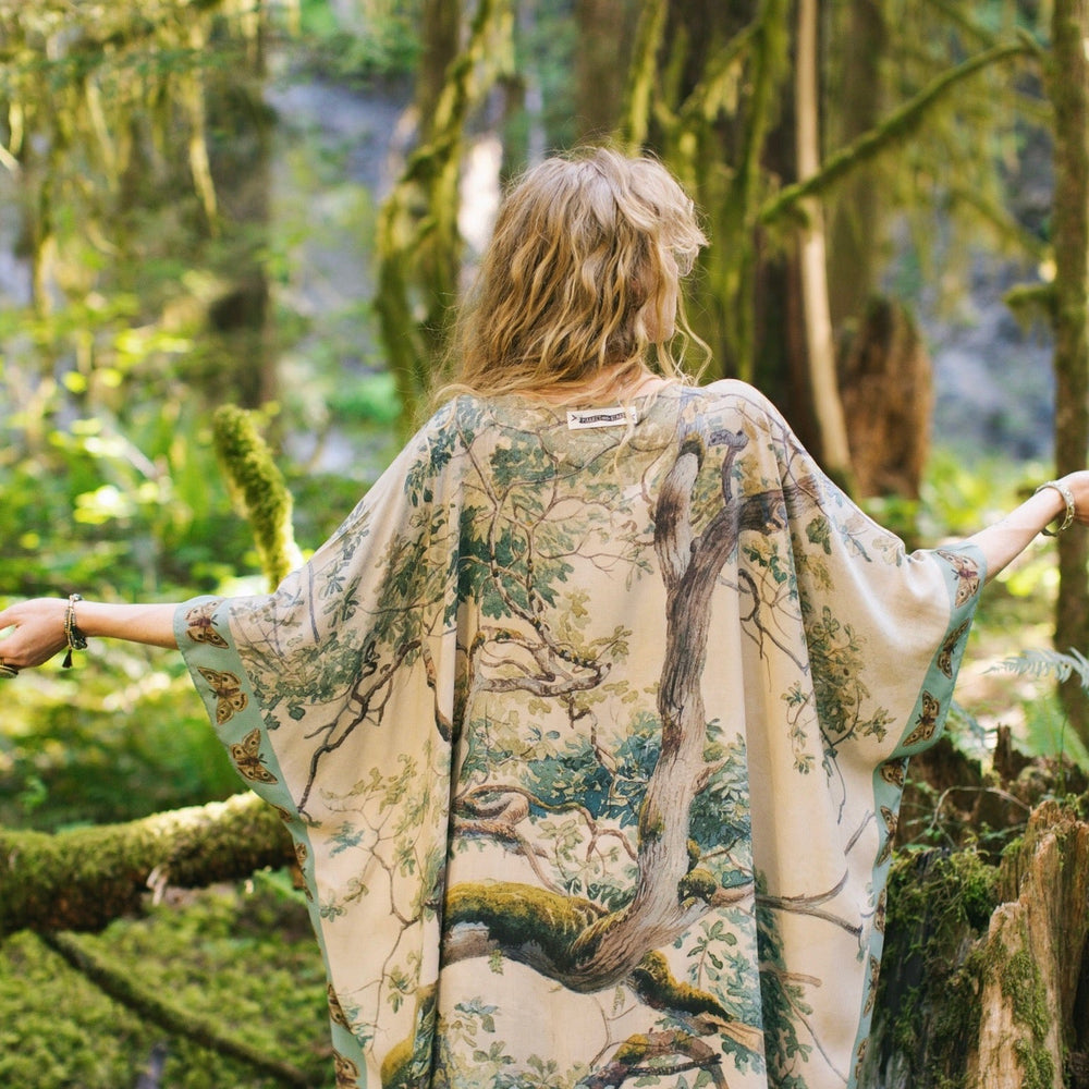 
                  
                    Model wearing the Earth and Sky Goddess length kimono featuring majestic trees by Charles Aston and antique moth illustrations – a dreamy tribute to nature – Market of Stars.
                  
                