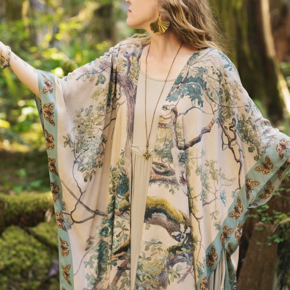 
                  
                    Model wearing the Earth and Sky Goddess length kimono featuring majestic trees by Charles Aston and antique moth illustrations – a dreamy tribute to nature – Market of Stars.
                  
                
