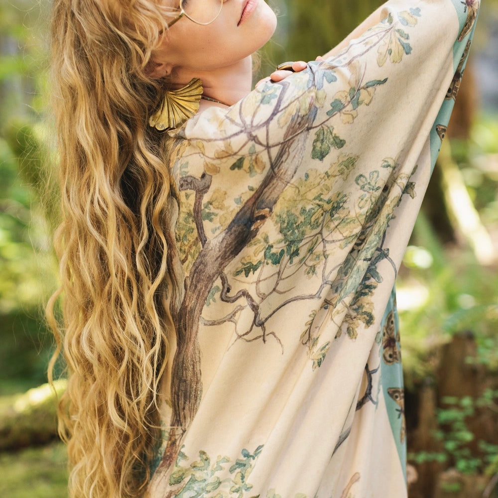 
                  
                    Model wearing the Earth and Sky Goddess length kimono featuring majestic trees by Charles Aston and antique moth illustrations – a dreamy tribute to nature – Market of Stars.
                  
                