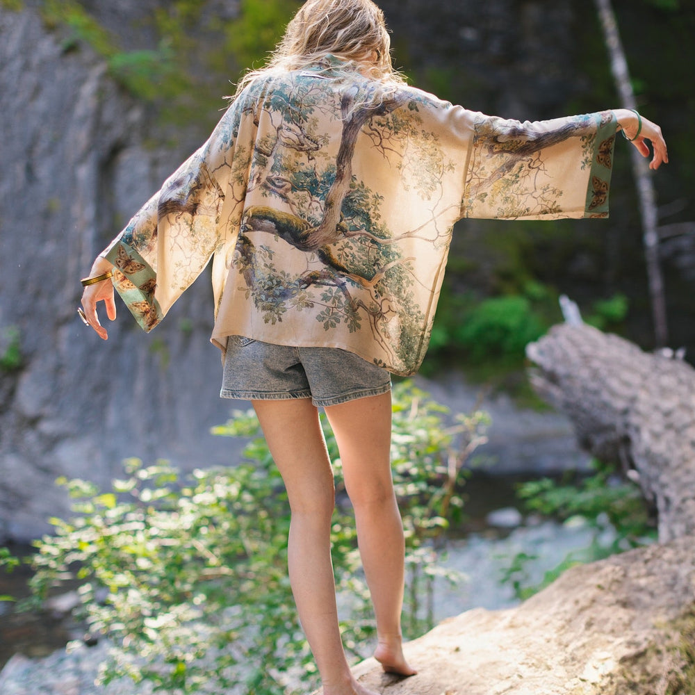 
                  
                    Model wearing Earth and Sky Pixie Duster featuring Charles Aston’s tree art and antique moth illustrations – a soft, nature-inspired layering piece – Market of Stars.
                  
                