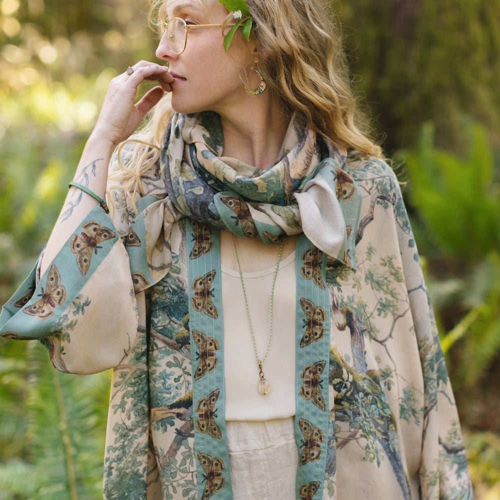 
                  
                    Model wearing Earth and Sky Pixie Duster featuring Charles Aston’s tree art and antique moth illustrations – a soft, nature-inspired layering piece – Market of Stars.
                  
                