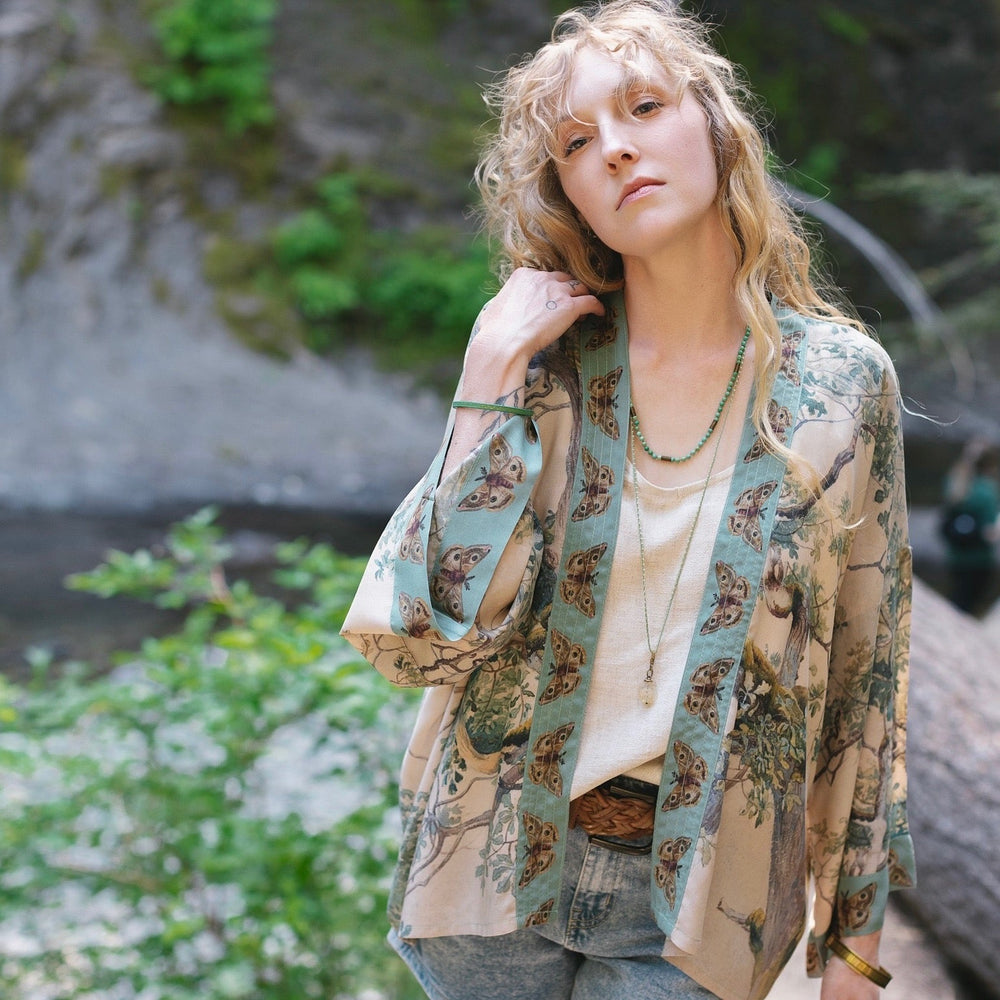 
                  
                    Model wearing Earth and Sky Pixie Duster featuring Charles Aston’s tree art and antique moth illustrations – a soft, nature-inspired layering piece – Market of Stars.
                  
                