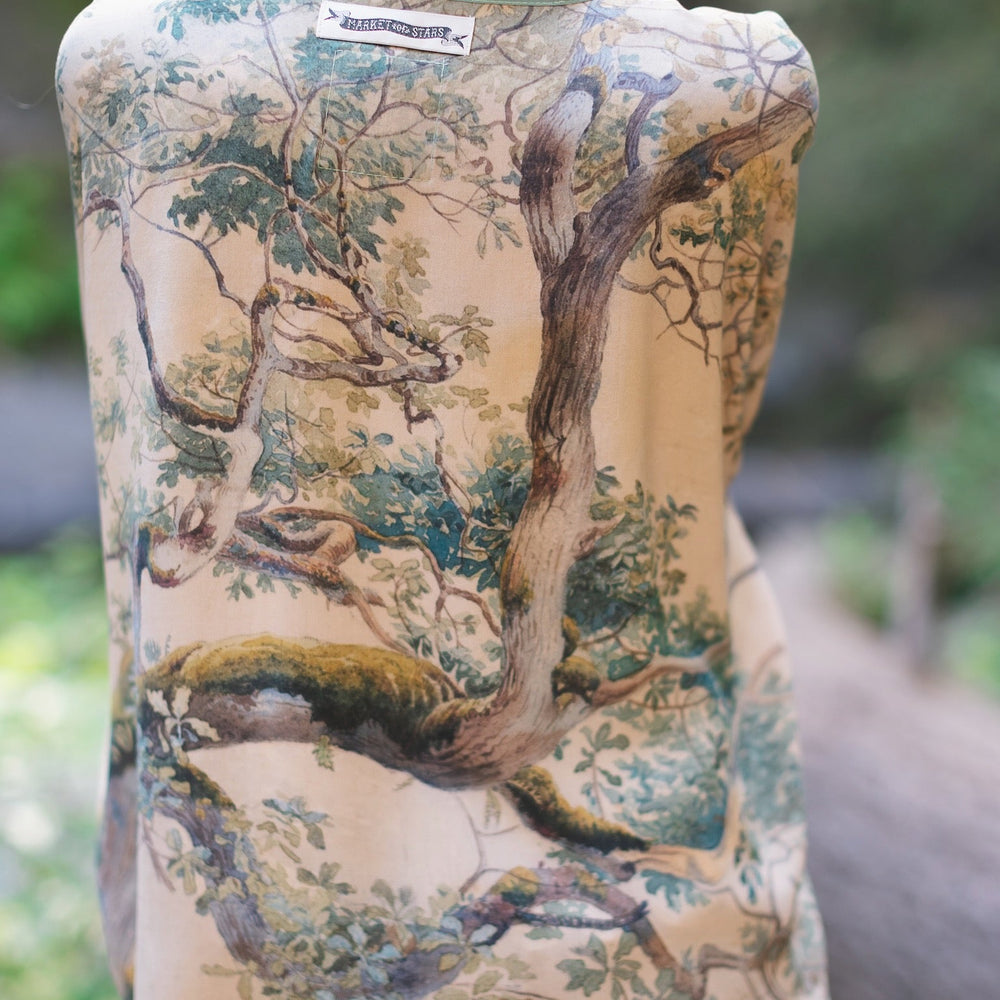 
                  
                    Model wearing Earth and Sky Pixie Duster featuring Charles Aston’s tree art and antique moth illustrations – a soft, nature-inspired layering piece – Market of Stars.
                  
                