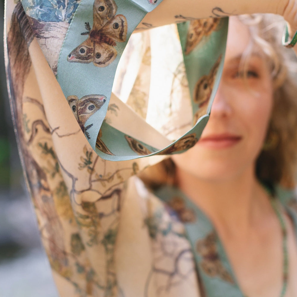 
                  
                    Model wearing Earth and Sky Pixie Duster featuring Charles Aston’s tree art and antique moth illustrations – a soft, nature-inspired layering piece – Market of Stars.
                  
                