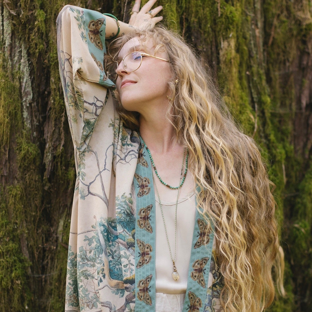 
                  
                    Model wearing Earth and Sky Pixie Duster featuring Charles Aston’s tree art and antique moth illustrations – a soft, nature-inspired layering piece – Market of Stars.
                  
                