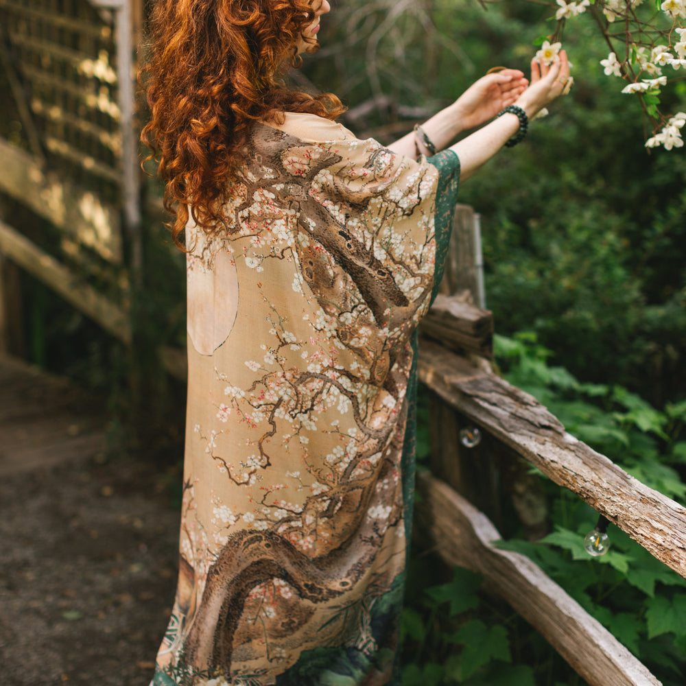 
                  
                    Model wearing Fable Goddess Duster featuring antique Japanese art, cherry and peach blossoms, nightingales, deer, and French block prints - Market of Stars
                  
                