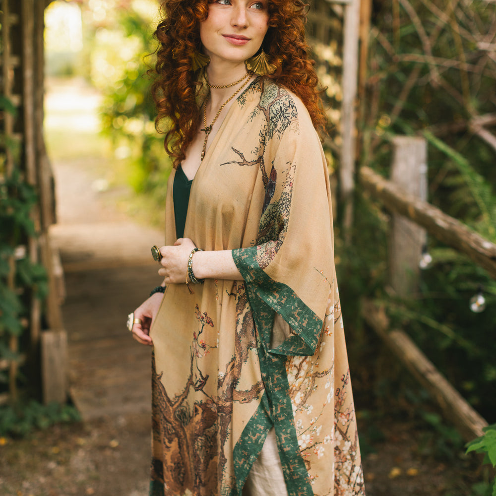 
                  
                    Model wearing Fable Goddess Duster featuring antique Japanese art, cherry and peach blossoms, nightingales, deer, and French block prints - Market of Stars
                  
                