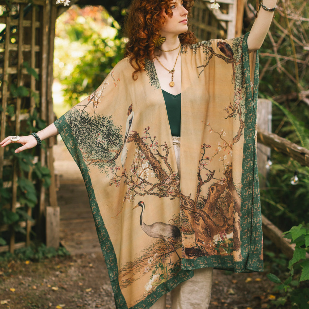 
                  
                    Model wearing Fable Goddess Duster featuring antique Japanese art, cherry and peach blossoms, nightingales, deer, and French block prints - Market of Stars
                  
                