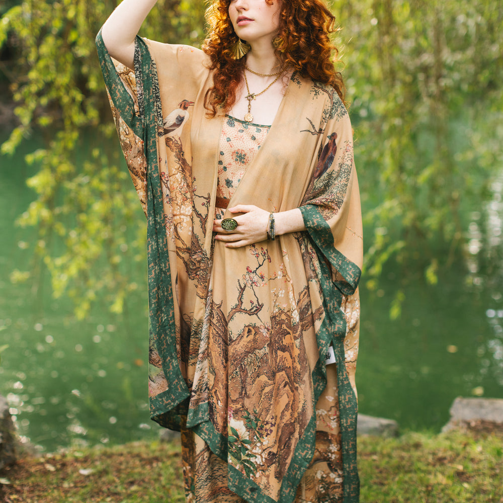 
                  
                    Model wearing Fable Goddess Duster featuring antique Japanese art, cherry and peach blossoms, nightingales, deer, and French block prints - Market of Stars
                  
                