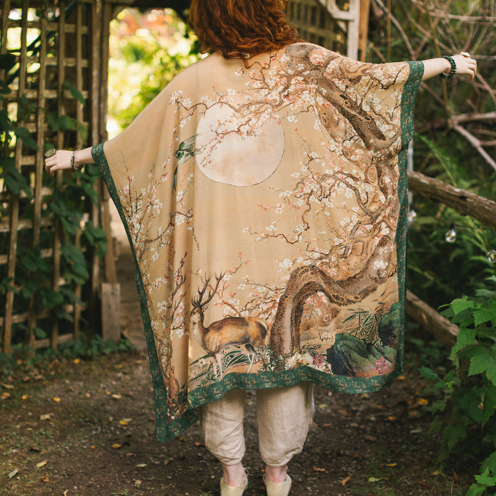 
                  
                    Model wearing Fable Goddess Duster featuring antique Japanese art, cherry and peach blossoms, nightingales, deer, and French block prints - Market of Stars
                  
                