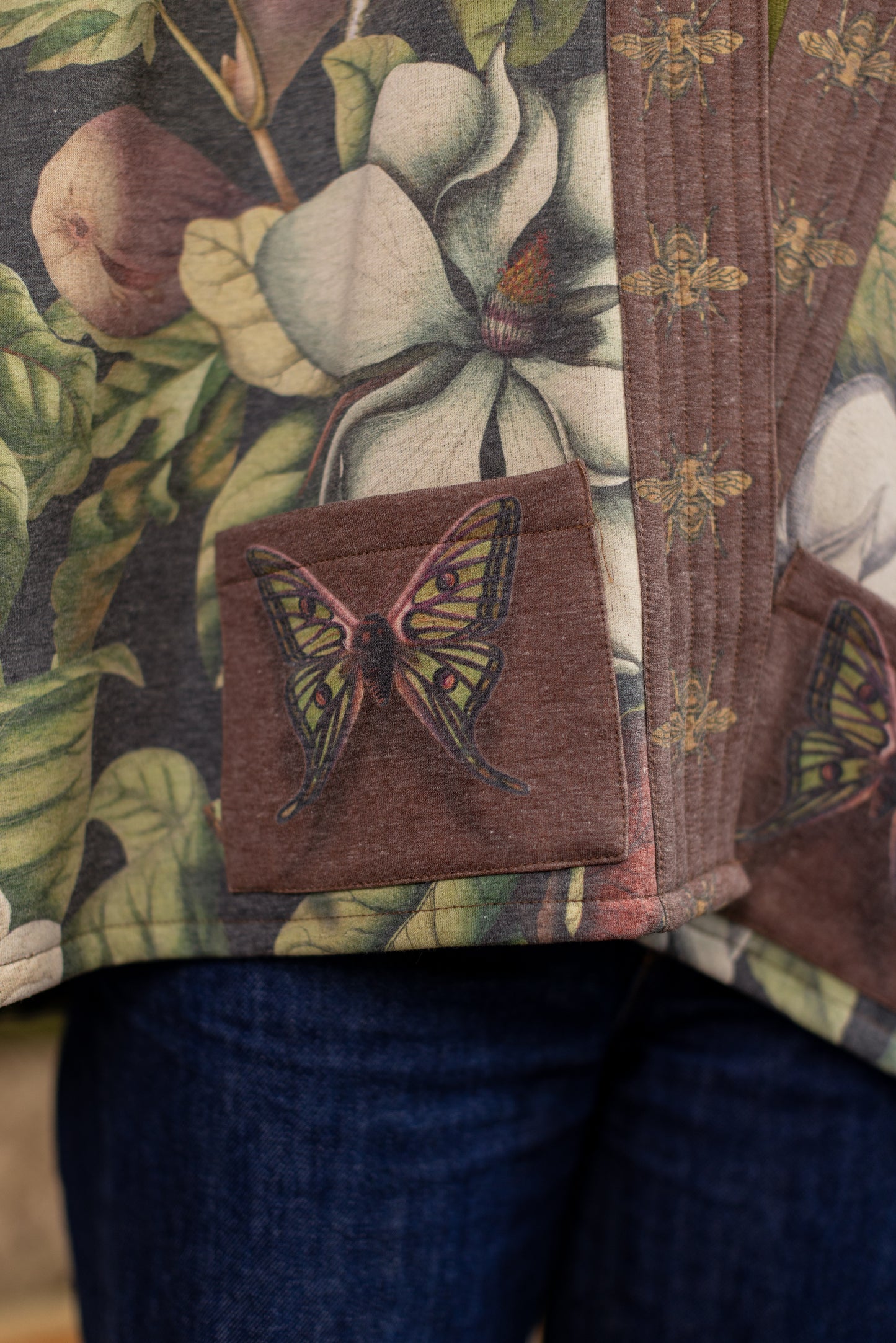 Model wearing a cozy cardigan lined with fleece featuring vintage magnolia lithographs, delicate moth etchings, and charming bumblebee trim - Market of stars