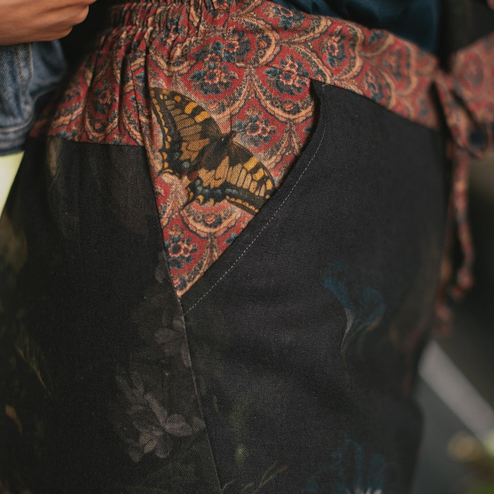 
                  
                    Model wearing the Folklore Artist Pant featuring the Bird-of-Peace embroidery and unfinished William Morris textile designs—artful linen blend pants by Market of Stars.
                  
                