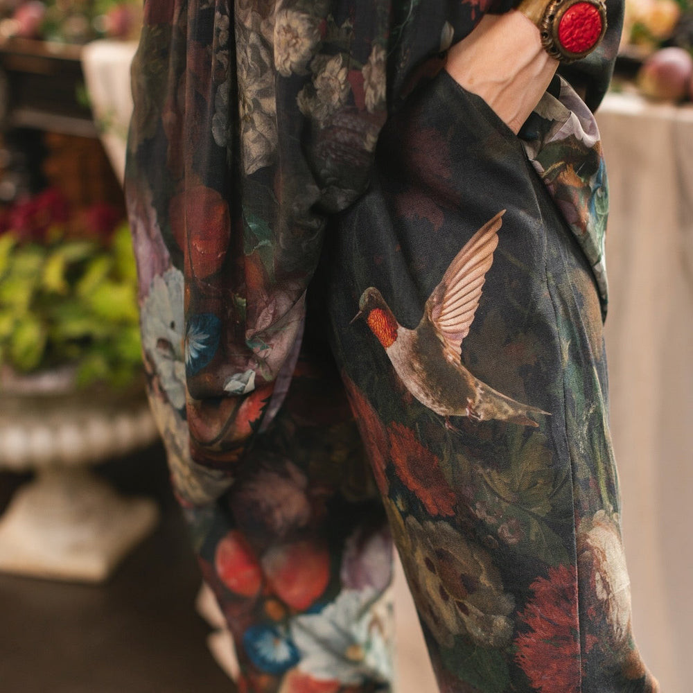 
                  
                    Model wearing the Folklore Artist Pant featuring the Bird-of-Peace embroidery and unfinished William Morris textile designs—artful linen blend pants by Market of Stars.
                  
                