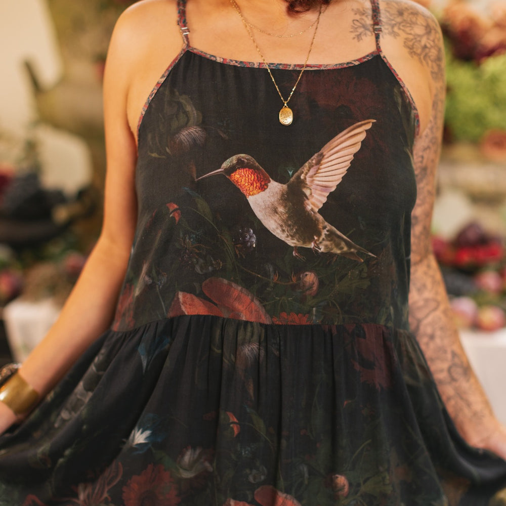 Model wearing Flight of Fancy Bohéme Slip Dress featuring hummingbirds and a vibrant floral bouquet inspired by 1700s still-life paintings by Rachel Ruysch – Market of Stars.