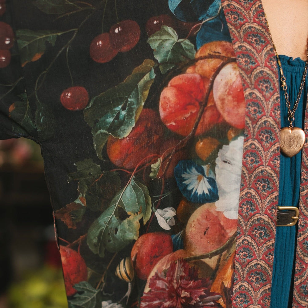 
                  
                    Model showcasing the Flight of Fancy Opera Robe featuring vibrant hummingbirds and historic floral paintings by Rachel Ruysch – Market of Stars.
                  
                
