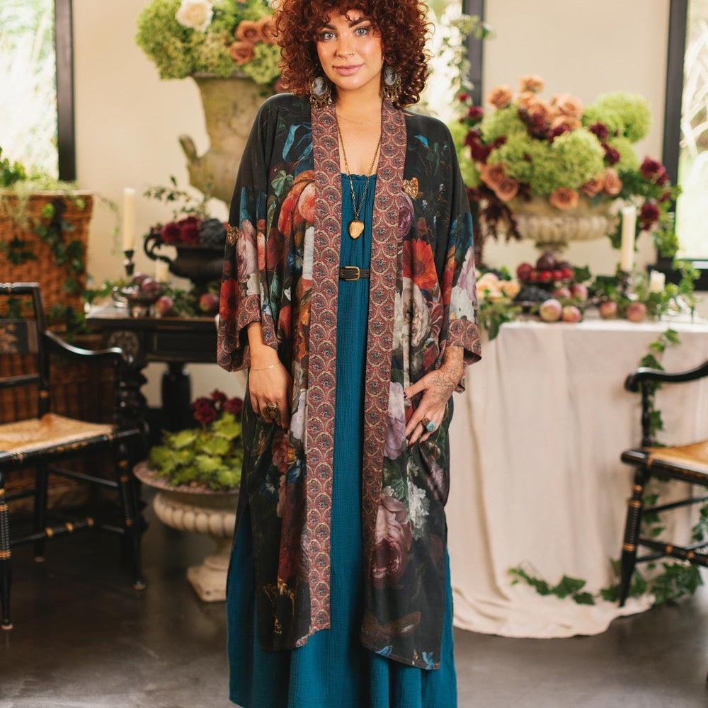 
                  
                    Model showcasing the Flight of Fancy Opera Robe featuring vibrant hummingbirds and historic floral paintings by Rachel Ruysch – Market of Stars.
                  
                