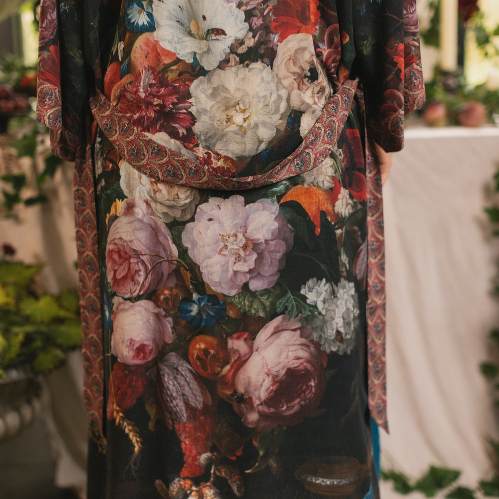 
                  
                    Model showcasing the Flight of Fancy Opera Robe featuring vibrant hummingbirds and historic floral paintings by Rachel Ruysch – Market of Stars.
                  
                