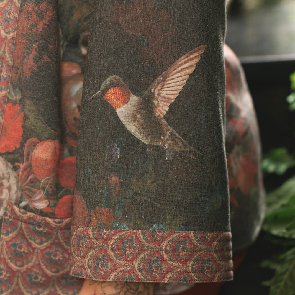 
                  
                    Model wearing a cozy cardigan lined with fleece showcasing hummingbirds and 1700s floral paintings - Market of Stars
                  
                