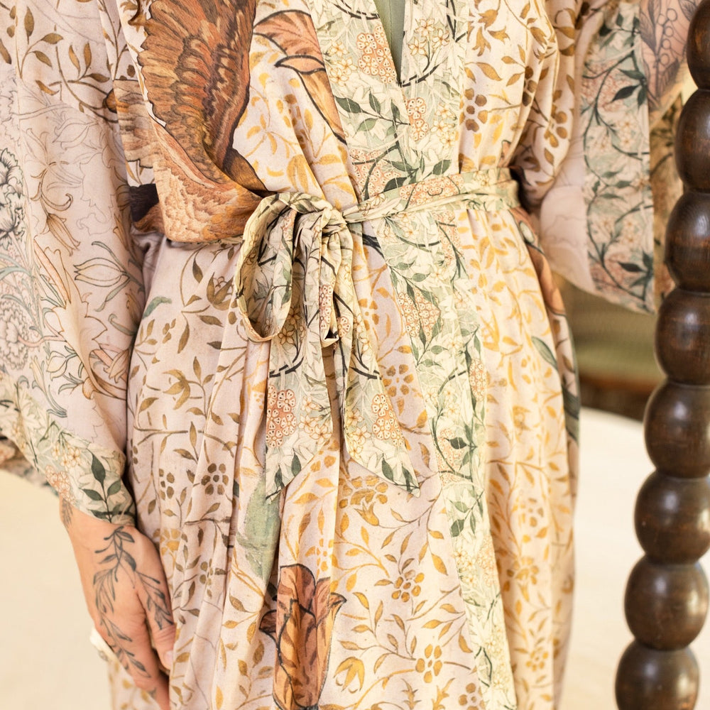 
                  
                    Model wearing opera-length kimono featuring the embroidered Bird-of-Peace by Kim Donohoe and unfinished William Morris panels celebrating artistic process – Market of Stars.
                  
                