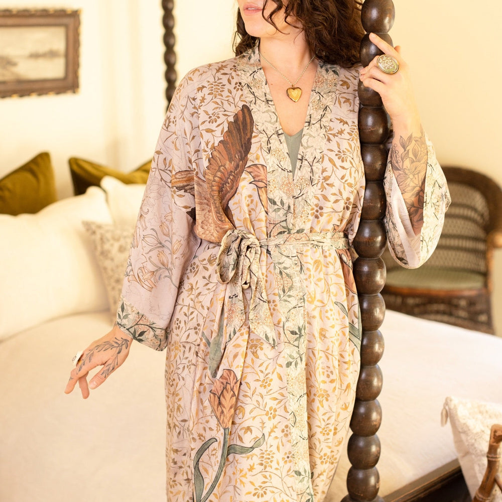 
                  
                    Model wearing opera-length kimono featuring the embroidered Bird-of-Peace by Kim Donohoe and unfinished William Morris panels celebrating artistic process – Market of Stars.
                  
                