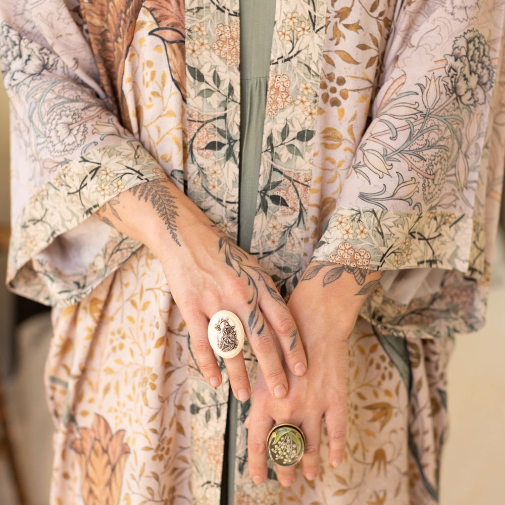 
                  
                    Model wearing opera-length kimono featuring the embroidered Bird-of-Peace by Kim Donohoe and unfinished William Morris panels celebrating artistic process – Market of Stars.
                  
                