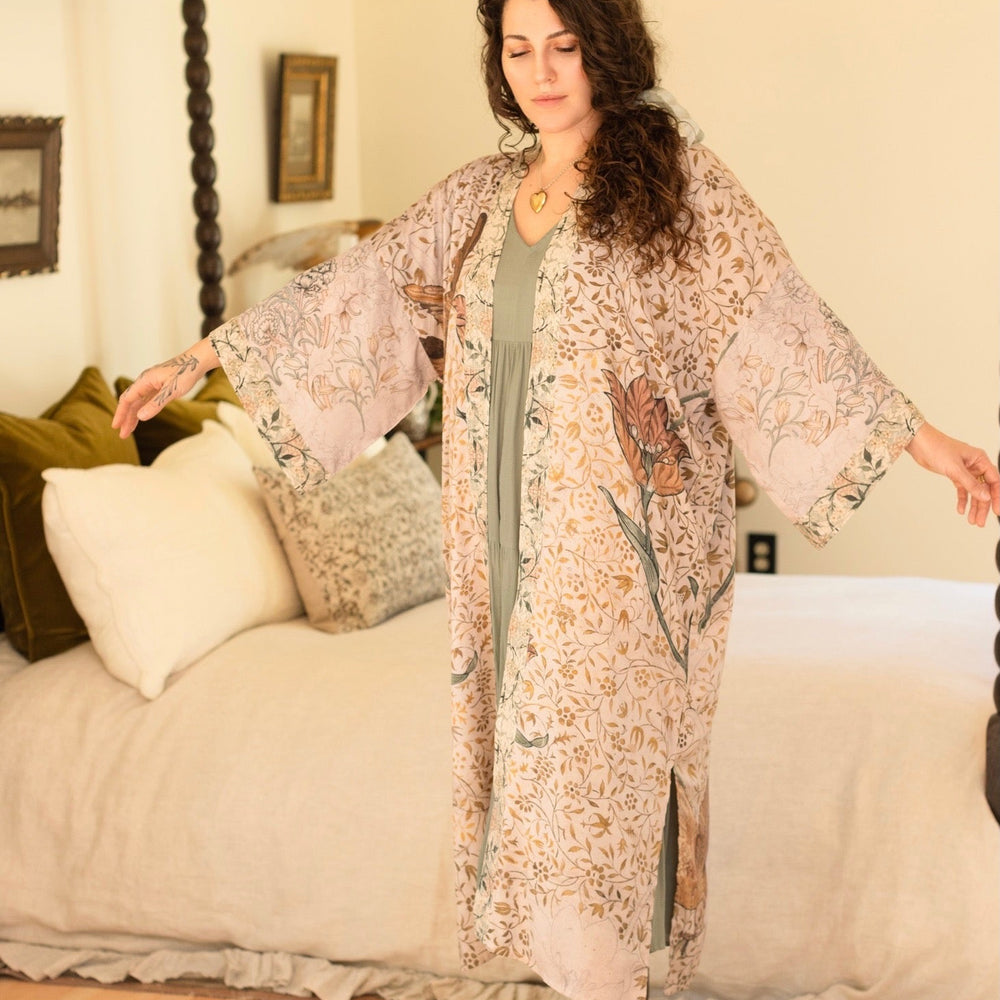 
                  
                    Model wearing opera-length kimono featuring the embroidered Bird-of-Peace by Kim Donohoe and unfinished William Morris panels celebrating artistic process – Market of Stars.
                  
                