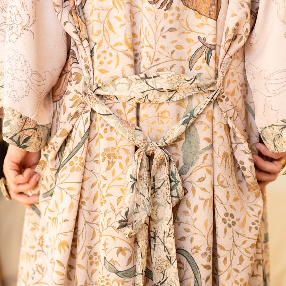 
                  
                    Model wearing opera-length kimono featuring the embroidered Bird-of-Peace by Kim Donohoe and unfinished William Morris panels celebrating artistic process – Market of Stars.
                  
                