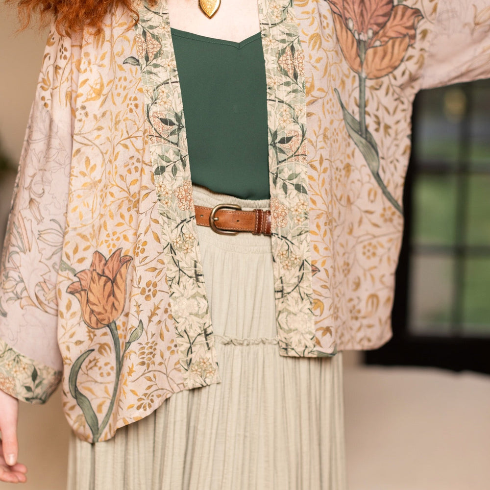 
                  
                    Model wearing full-length Folklore opera duster featuring Bird-of-Peace embroidery and unfinished William Morris textile panels in soft earthy tones – Market of Stars.
                  
                