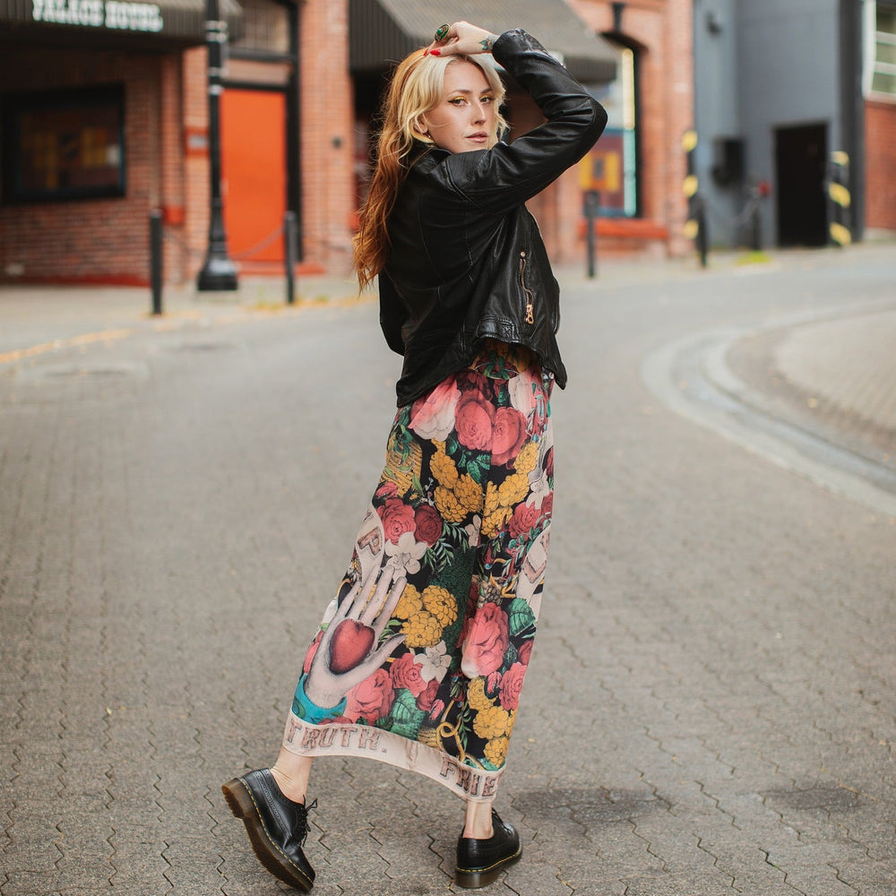 
                  
                    Model wearing reversible bamboo viscose slip dress featuring vintage symbols of friendship, love, and truth with pink and rose palette – Market of Stars.
                  
                