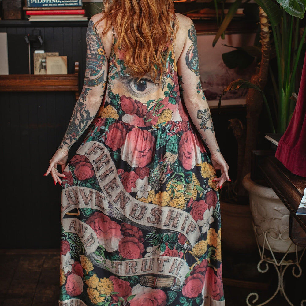 
                  
                    Model wearing reversible bamboo viscose slip dress featuring vintage symbols of friendship, love, and truth with pink and rose palette – Market of Stars.
                  
                