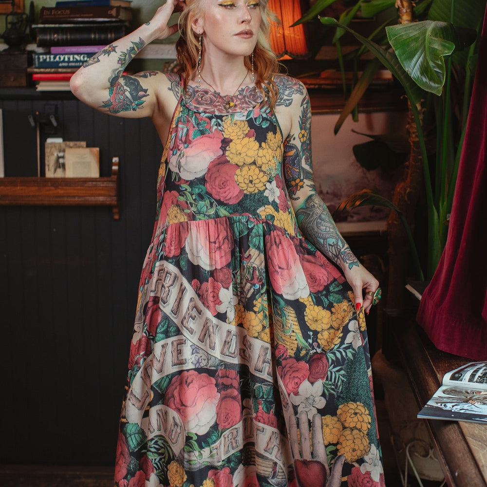
                  
                    Model wearing reversible bamboo viscose slip dress featuring vintage symbols of friendship, love, and truth with pink and rose palette – Market of Stars.
                  
                