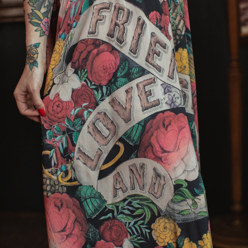 
                  
                    Model wearing reversible bamboo viscose slip dress featuring vintage symbols of friendship, love, and truth with pink and rose palette – Market of Stars.
                  
                
