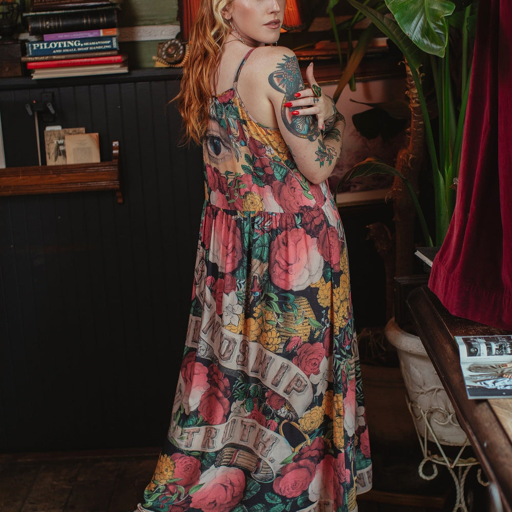 
                  
                    Model wearing reversible bamboo viscose slip dress featuring vintage symbols of friendship, love, and truth with pink and rose palette – Market of Stars.
                  
                