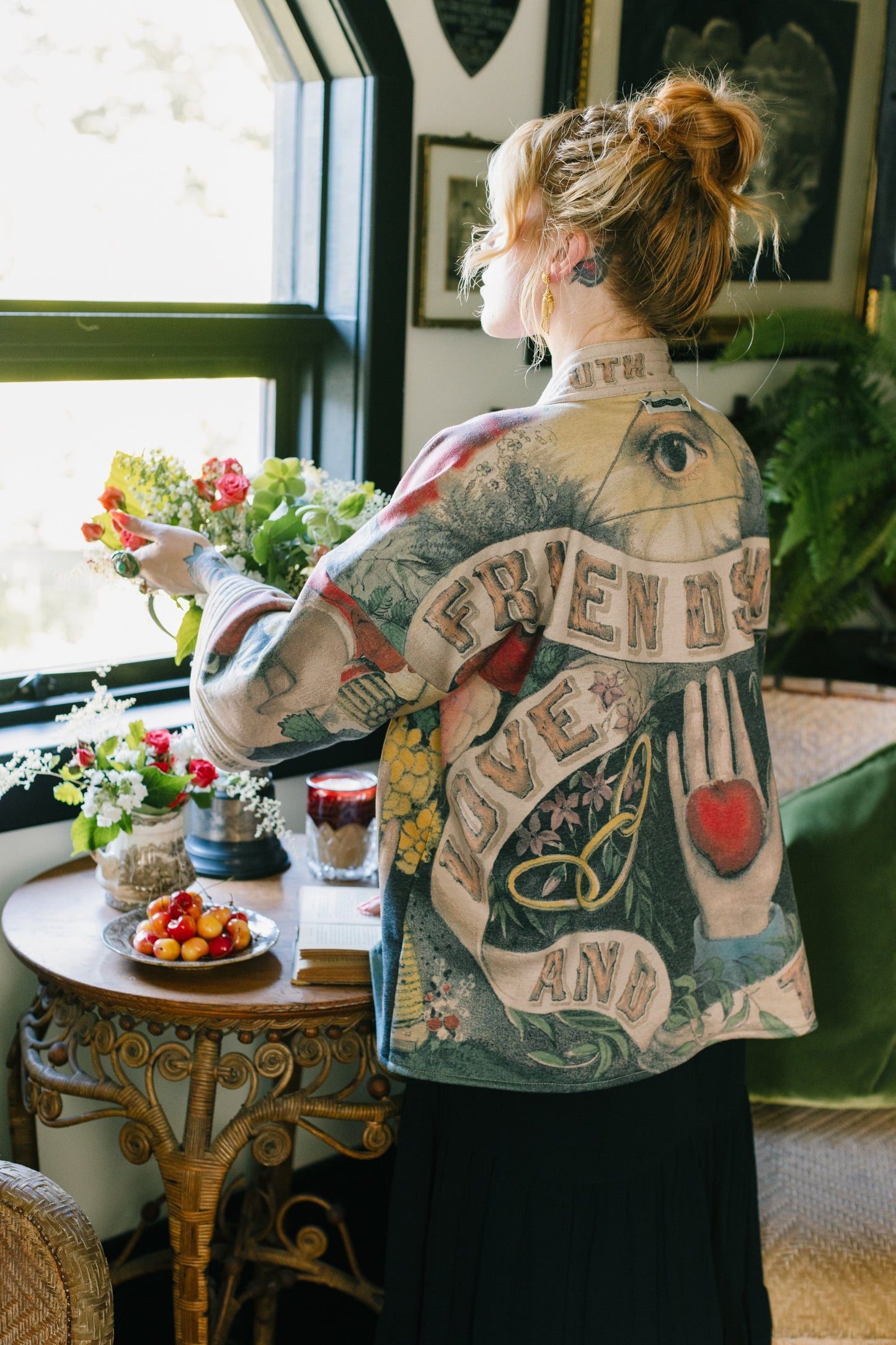 Model wearing cozy printed cardigan with vintage symbols of love, truth, and friendship, featuring charming wood-grain trim and patch pockets – Market of Stars.
