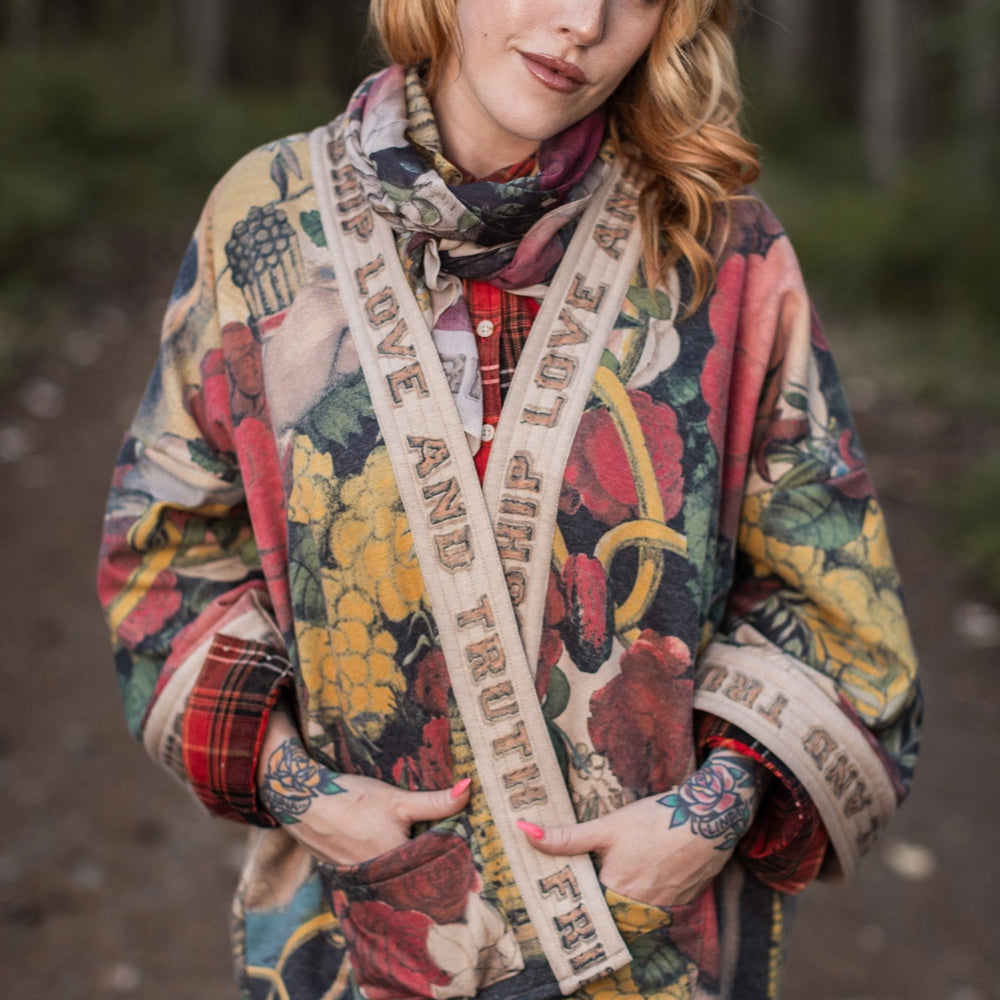 Model wearing cozy printed cardigan with vintage symbols of love, truth, and friendship, featuring charming wood-grain trim and patch pockets – Market of Stars.