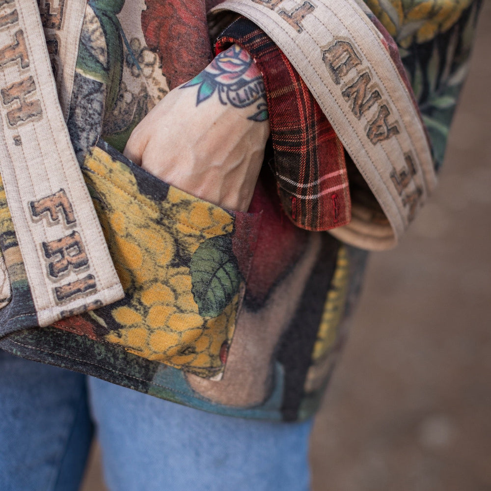 
                  
                    Model wearing cozy printed cardigan with vintage symbols of love, truth, and friendship, featuring charming wood-grain trim and patch pockets – Market of Stars.
                  
                