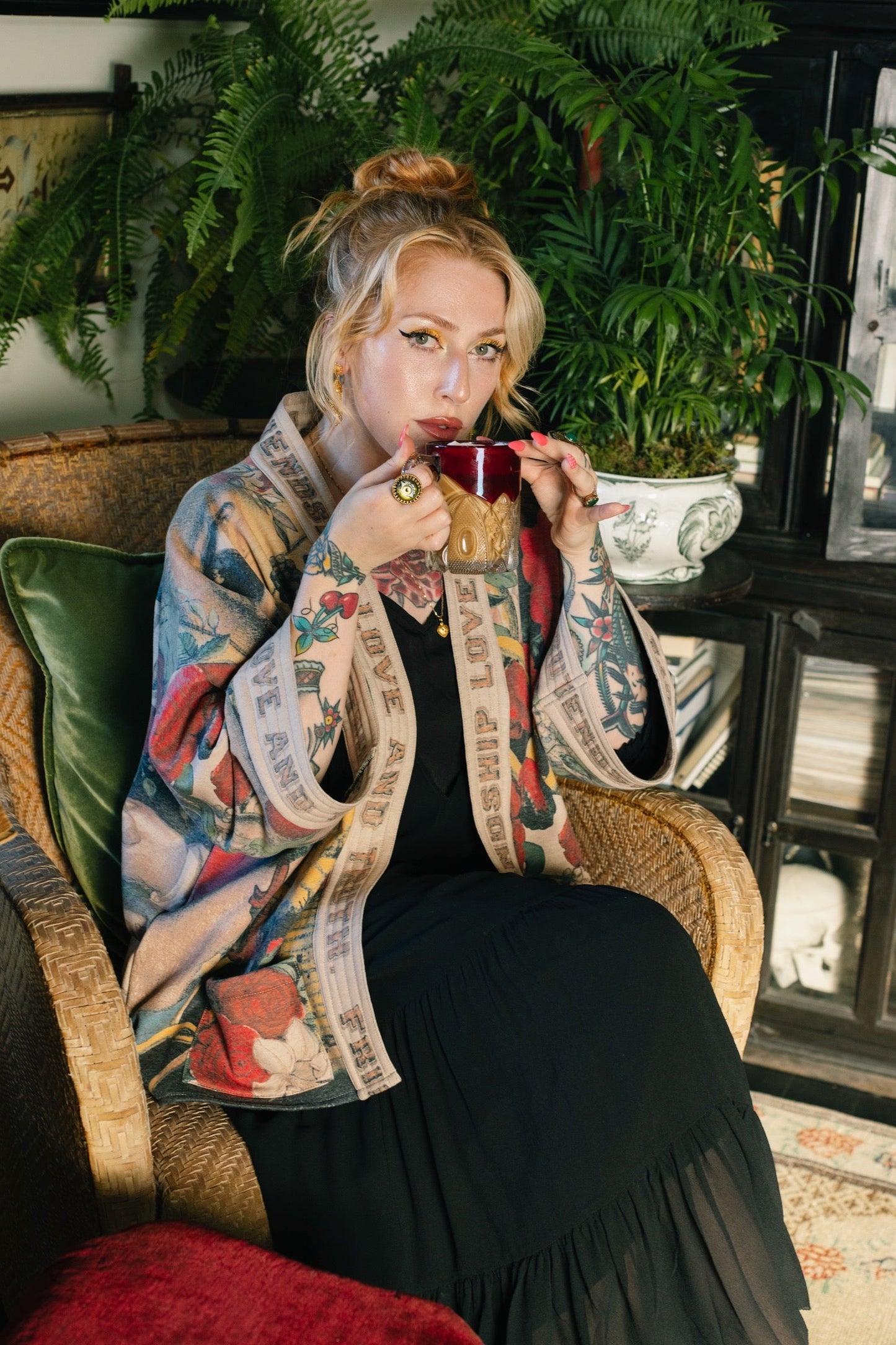 Model wearing cozy printed cardigan with vintage symbols of love, truth, and friendship, featuring charming wood-grain trim and patch pockets – Market of Stars.