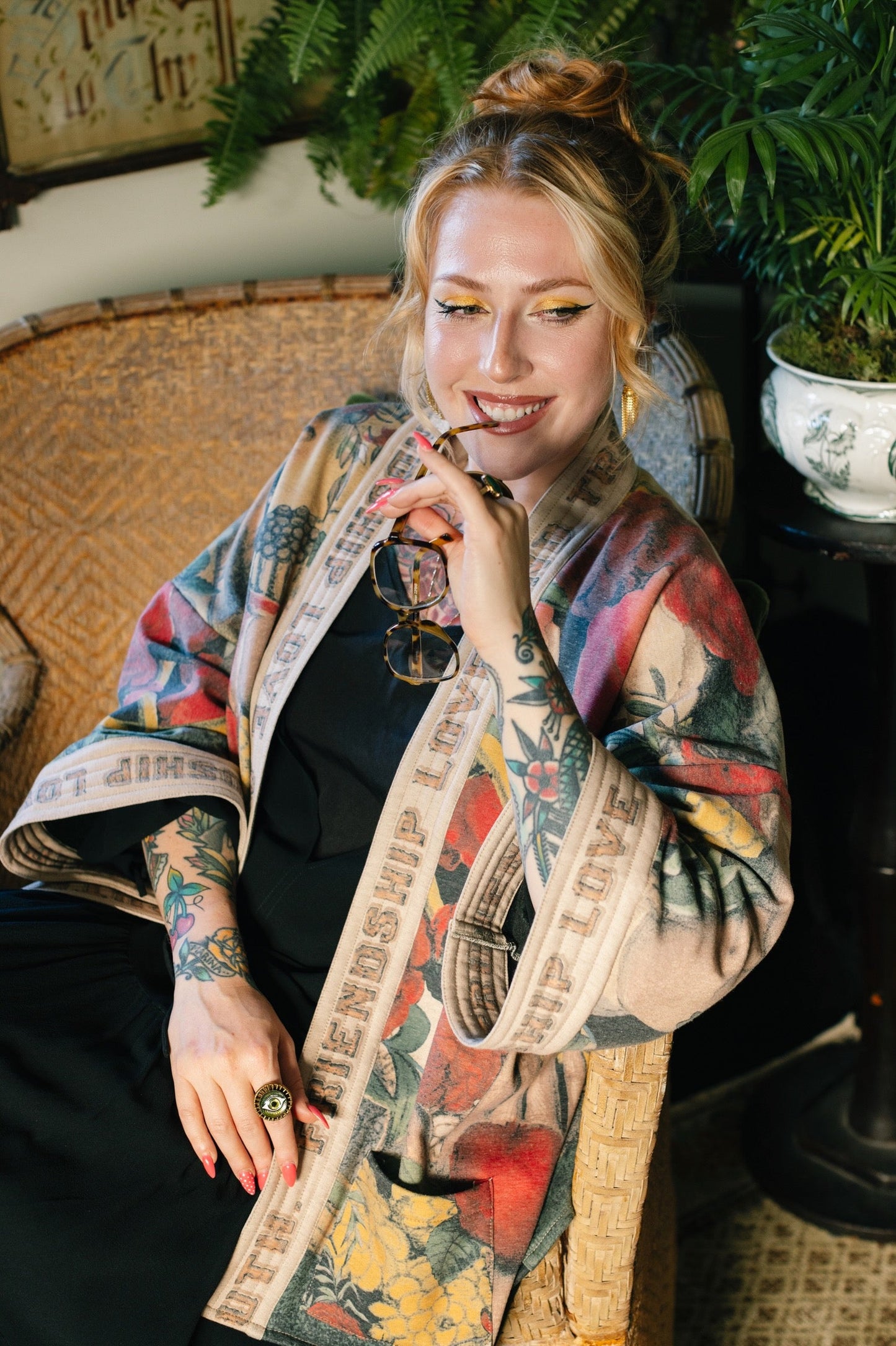 Model wearing cozy printed cardigan with vintage symbols of love, truth, and friendship, featuring charming wood-grain trim and patch pockets – Market of Stars.