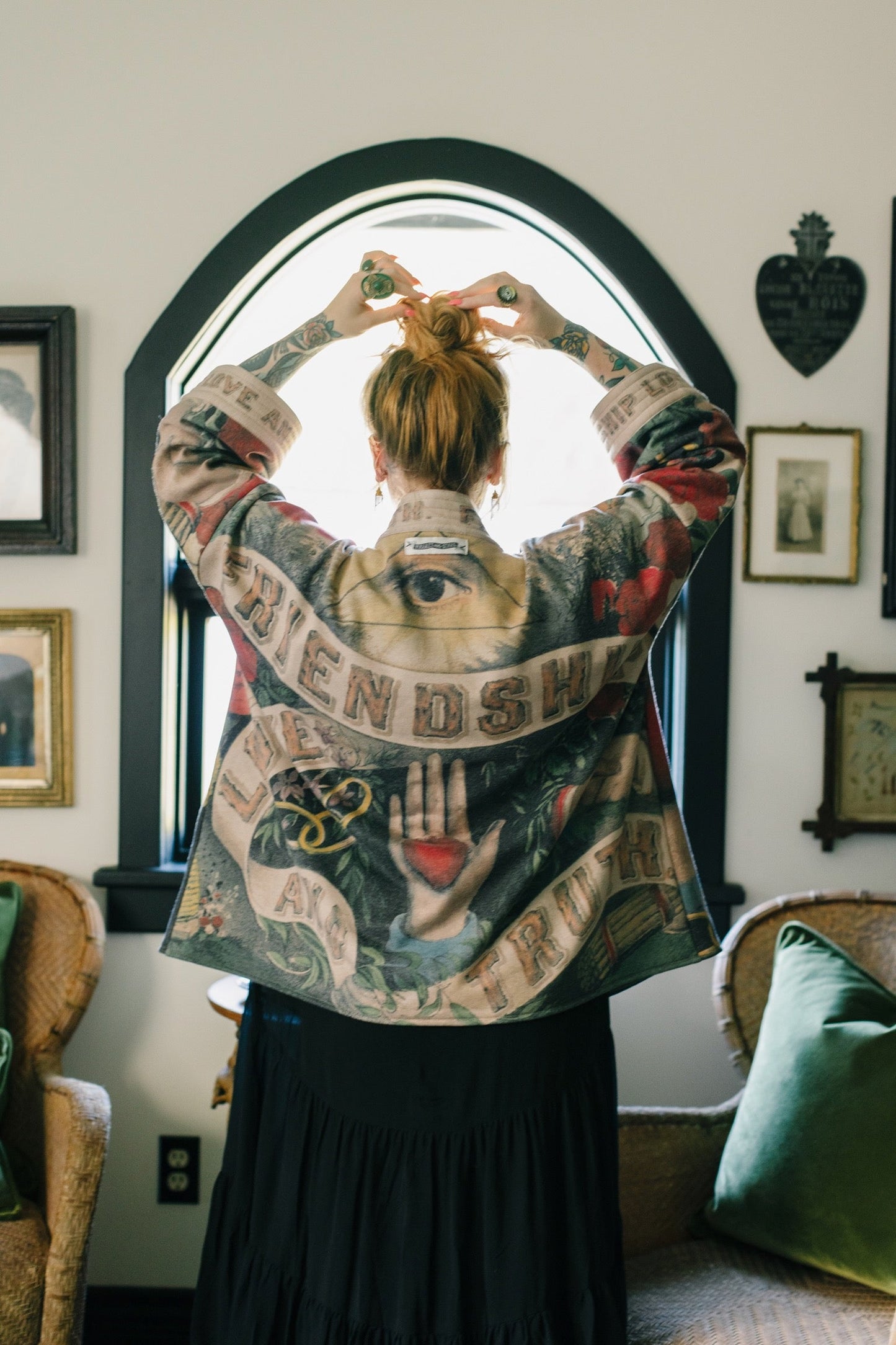 Model wearing cozy printed cardigan with vintage symbols of love, truth, and friendship, featuring charming wood-grain trim and patch pockets – Market of Stars.