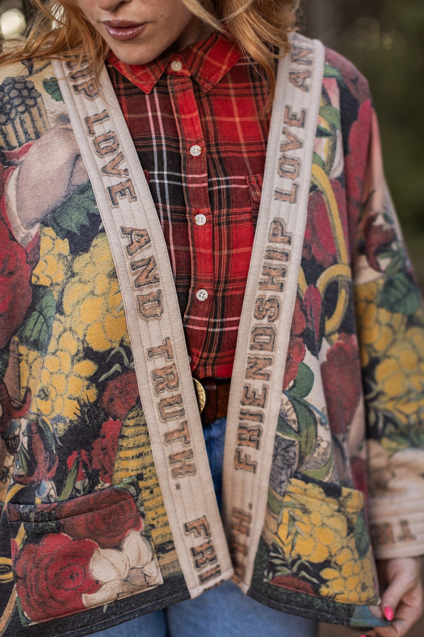 Model wearing cozy printed cardigan with vintage symbols of love, truth, and friendship, featuring charming wood-grain trim and patch pockets – Market of Stars.