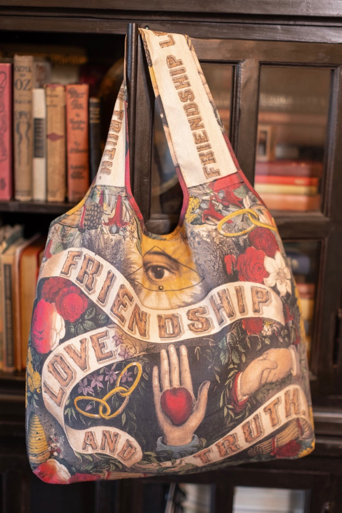 Model holding Friendship Love and Truth tote featuring historic symbols of cooperation, teamwork, eternal love, and truth from an 1880s print – Market of Stars.