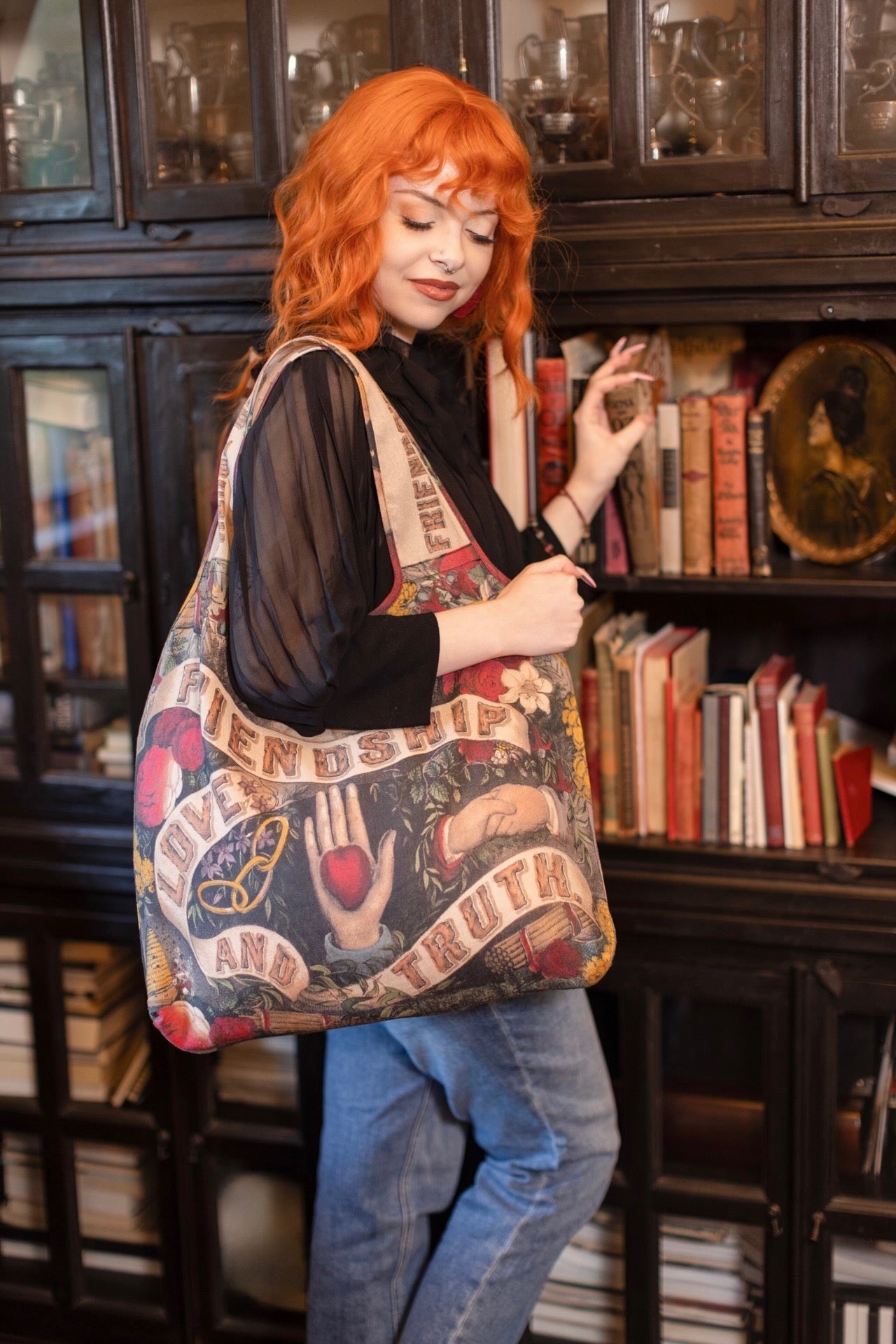 Model holding Friendship Love and Truth tote featuring historic symbols of cooperation, teamwork, eternal love, and truth from an 1880s print – Market of Stars.