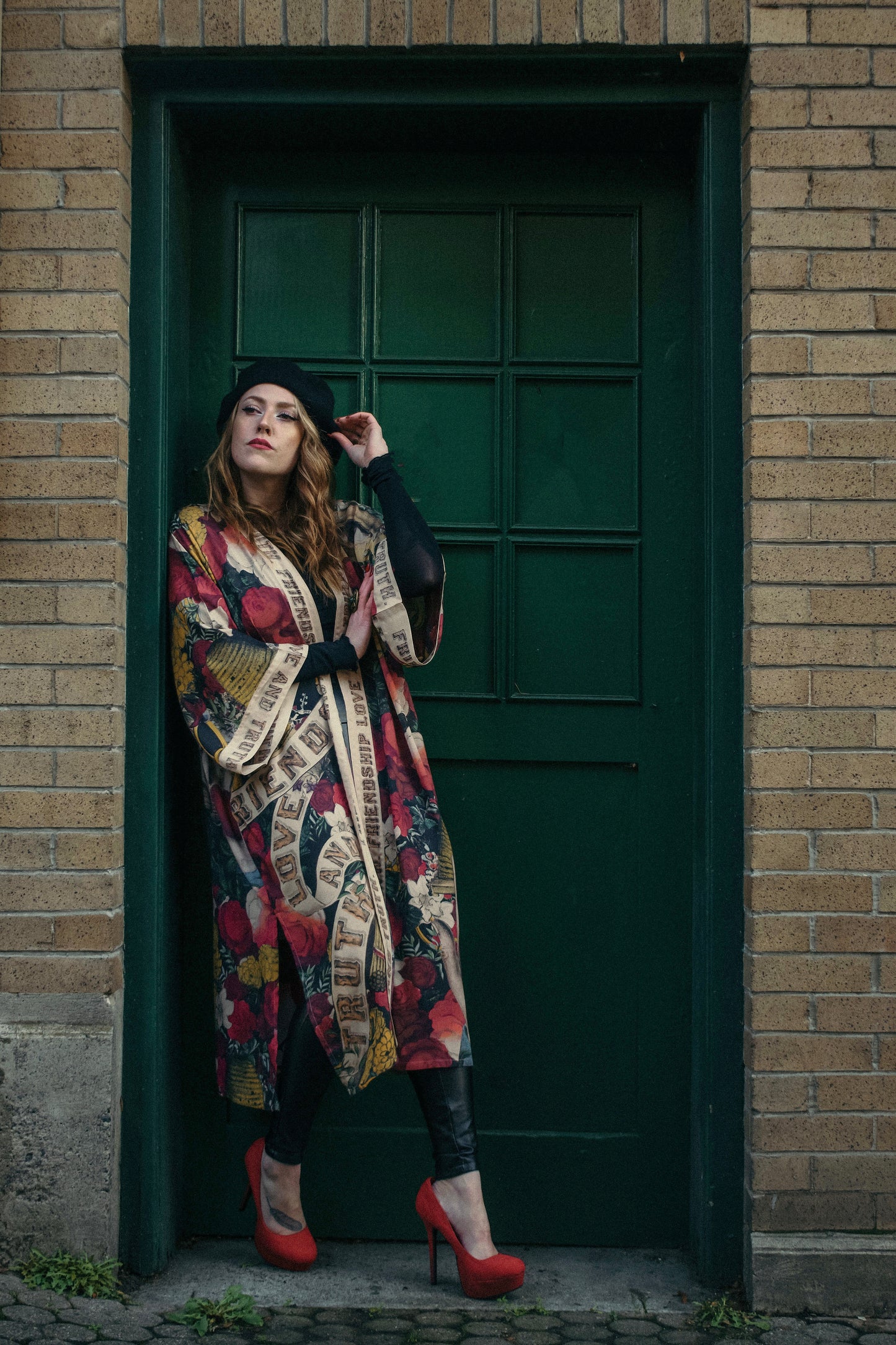 Model wearing our long, eclectic opera duster featuring vintage symbols of love, kindness, and truth in a bold archive-inspired print with removable belt – Market of Stars.