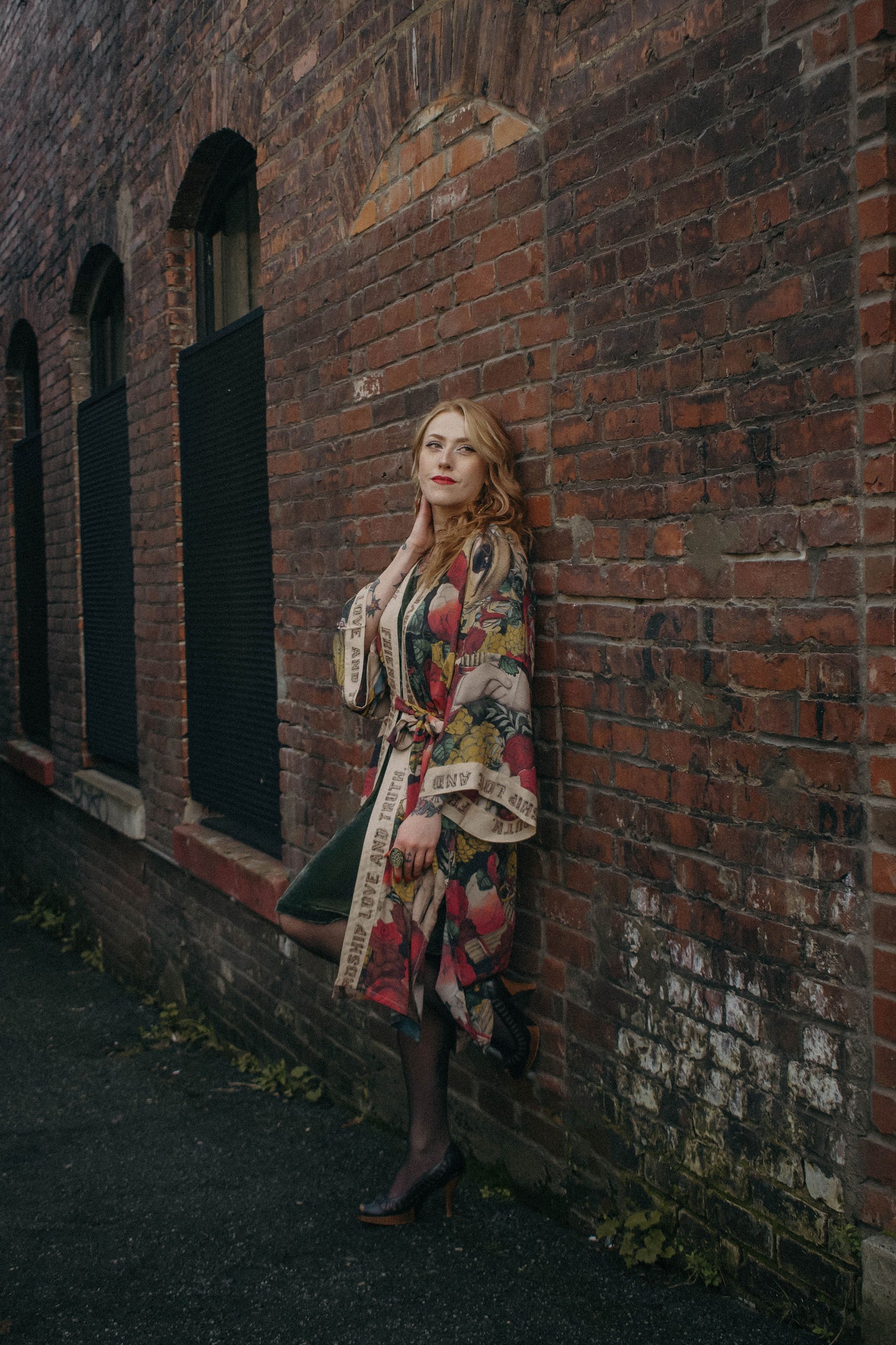 Model wearing our long, eclectic opera duster featuring vintage symbols of love, kindness, and truth in a bold archive-inspired print with removable belt – Market of Stars.